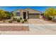 Charming single-story home with a well-maintained lawn, desert landscaping, and an attached two-car garage at 17344 W Red Fox Rd, Surprise, AZ 85387