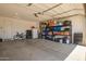 Three-car garage features a door, bike, work bench, and shelving units at 17344 W Red Fox Rd, Surprise, AZ 85387