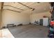 Spacious three-car garage with a door, work bench, and room for storage at 17344 W Red Fox Rd, Surprise, AZ 85387