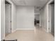 Bright hallway with neutral paint, tile floors, and doorways leading to various rooms in the home at 17344 W Red Fox Rd, Surprise, AZ 85387