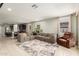 Open-concept living area featuring a sectional sofa, tile flooring, and abundant natural light from large windows at 17344 W Red Fox Rd, Surprise, AZ 85387