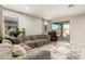 Bright living room featuring a sectional couch, and a sliding glass door leading to an outdoor patio at 17344 W Red Fox Rd, Surprise, AZ 85387