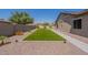 An inviting backyard features green turf surrounded by desert landscaping for easy maintenance at 19042 E Arrowhead Trl, Queen Creek, AZ 85142