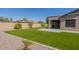 Spacious backyard with green turf, desert landscaping, a covered patio, and an inviting atmosphere at 19042 E Arrowhead Trl, Queen Creek, AZ 85142