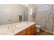 Well-lit bathroom featuring a double sink vanity with wood cabinets and a shower-tub combo at 19042 E Arrowhead Trl, Queen Creek, AZ 85142