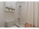 Cozy bathroom showcasing a shower-tub combination, white shower curtain and convenient toilet paper storage at 19042 E Arrowhead Trl, Queen Creek, AZ 85142