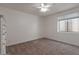 Bright bedroom with plush carpet, ceiling fan, and a window letting in natural light at 19042 E Arrowhead Trl, Queen Creek, AZ 85142