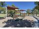 Community playground featuring climbing structures, slides and swings under sun shades, providing a fun and safe recreation area at 19042 E Arrowhead Trl, Queen Creek, AZ 85142