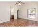 Bedroom featuring wood flooring, a ceiling fan, an ensuite bathroom, and a large window with natural light at 1976 N Lemon Tree Ln # 16, Chandler, AZ 85224