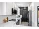 Bright kitchen featuring white cabinets, stainless steel appliances and a contrasting black brick wall at 201 S Greenfield Rd # 215, Mesa, AZ 85206