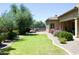 Expansive backyard features a well-manicured lawn, desert landscaping, and covered patio at 20243 E Poco Calle --, Queen Creek, AZ 85142