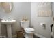 Powder room featuring a pedestal sink, toilet with decorative baskets, and a modern, neutral design at 20243 E Poco Calle --, Queen Creek, AZ 85142