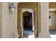 Covered entryway showcasing an ornate light fixture and a view of a dark wooden door with a floral wreath at 20243 E Poco Calle --, Queen Creek, AZ 85142