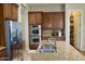 Modern kitchen displaying stainless steel appliances, double ovens, a granite island with a sink, and a walk-in pantry at 20243 E Poco Calle --, Queen Creek, AZ 85142