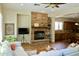 Open-concept living space with a stone fireplace, comfortable seating, and a view into the kitchen area at 20243 E Poco Calle --, Queen Creek, AZ 85142