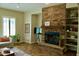 Cozy living room with a stone fireplace, built-in shelving, neutral-toned furniture, and tile flooring at 20243 E Poco Calle --, Queen Creek, AZ 85142