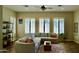 Comfortable living room with a sectional sofa, large windows, plantation shutters, and stylish decor at 20243 E Poco Calle --, Queen Creek, AZ 85142