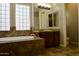Main bathroom with large soaking tub, block window, and double vanity with a tiled floor at 20243 E Poco Calle --, Queen Creek, AZ 85142