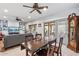 Open-concept dining area features a wooden table, ceiling fan, and sliding glass doors to the outdoor patio at 20450 N Shadow Mountain Dr, Surprise, AZ 85374