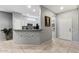 View of kitchen featuring white cabinets, breakfast bar and access to secondary living space at 20450 N Shadow Mountain Dr, Surprise, AZ 85374