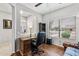 Home office with wood floors, desk, chair, and bright natural light from the window at 20450 N Shadow Mountain Dr, Surprise, AZ 85374
