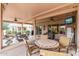 Spacious covered patio featuring a dining area, comfortable seating, and outdoor TV for entertainment at 20450 N Shadow Mountain Dr, Surprise, AZ 85374