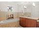 Bathroom featuring a tub with tile surround, large mirror, and accent lights at 2402 E Esplanade Ln # 204, Phoenix, AZ 85016