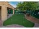 Beautiful backyard featuring a putting green, lush landscaping, and a charming patio area perfect for outdoor entertaining at 29228 N 48Th St, Cave Creek, AZ 85331
