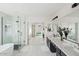 Bright bathroom with dual sinks, bathtub, and walk-in shower with glass door at 29228 N 48Th St, Cave Creek, AZ 85331