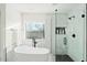 Bathroom featuring a soaking tub, glass enclosed shower, and sleek fixtures at 29228 N 48Th St, Cave Creek, AZ 85331