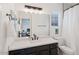 This bathroom features a large mirror with a dark vanity and marble shower at 29228 N 48Th St, Cave Creek, AZ 85331