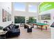 Spacious game room featuring a pool table, shuffleboard table, arcade game, and comfortable seating area at 29228 N 48Th St, Cave Creek, AZ 85331