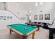 Spacious game room with a pool table, shuffle board and black accent stairs at 29228 N 48Th St, Cave Creek, AZ 85331