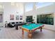 Large game room features a pool table, shuffleboard table, comfy sofa, and tall windows providing natural light at 29228 N 48Th St, Cave Creek, AZ 85331