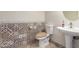 Bathroom features unique decorative tile and a pedestal sink, providing a touch of elegance and functionality at 29399 N 67Th Ave, Peoria, AZ 85383