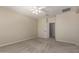A carpeted bedroom with neutral-colored walls features a door leading to an adjacent room at 29399 N 67Th Ave, Peoria, AZ 85383