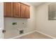Functional laundry room featuring overhead cabinets, tile flooring and washer/dryer hookups at 29399 N 67Th Ave, Peoria, AZ 85383