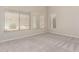 Large bright bedroom featuring a carpeted floor, neutral paint, and three windows at 29399 N 67Th Ave, Peoria, AZ 85383