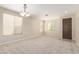 Spacious living room featuring neutral carpeting, three bright windows, and modern lighting at 29399 N 67Th Ave, Peoria, AZ 85383