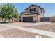 Charming two-story home showcasing desert landscaping, a spacious driveway, and a two-car garage at 3067 E Trigger Way, Gilbert, AZ 85297