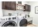 Well-organized laundry room with modern washer, dryer, utility sink, and stylish cabinetry for storage at 3067 E Trigger Way, Gilbert, AZ 85297