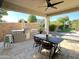 Outdoor patio area featuring a built-in grill, dining table, and well-maintained landscaping, perfect for entertaining at 3067 E Trigger Way, Gilbert, AZ 85297