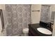 Bathroom showcases patterned shower curtain, black fixtures, vanity with dark countertop and gray accent towels at 3345 E University Dr # 47, Mesa, AZ 85213