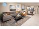 Open-concept living room with a cozy sofa, modern decor, and seamless flow to the dining area and kitchen at 3610 E Peralta Canyon Ln, San Tan Valley, AZ 85140