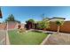 Backyard with lush artificial turf, rock landscaping, and mature landscaping at 3877 E Oxford Ln, Gilbert, AZ 85295
