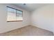 Comfortable bedroom with plush carpeting and natural light from a large window at 3877 E Oxford Ln, Gilbert, AZ 85295