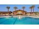Large pool with lounge chairs at the community center with palm trees at 39514 N Kaden Ln, San Tan Valley, AZ 85140