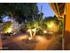 Desert landscaping is highlighted by warm lighting in this meticulously maintained backyard at 401 N Cholla St, Chandler, AZ 85224