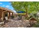 Charming brick patio featuring an umbrella-shaded table set, lush greenery, and outdoor seating area at 401 N Cholla St, Chandler, AZ 85224