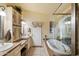 Elegant bathroom featuring double sinks, vanity, and a luxurious bathtub at 401 N Cholla St, Chandler, AZ 85224